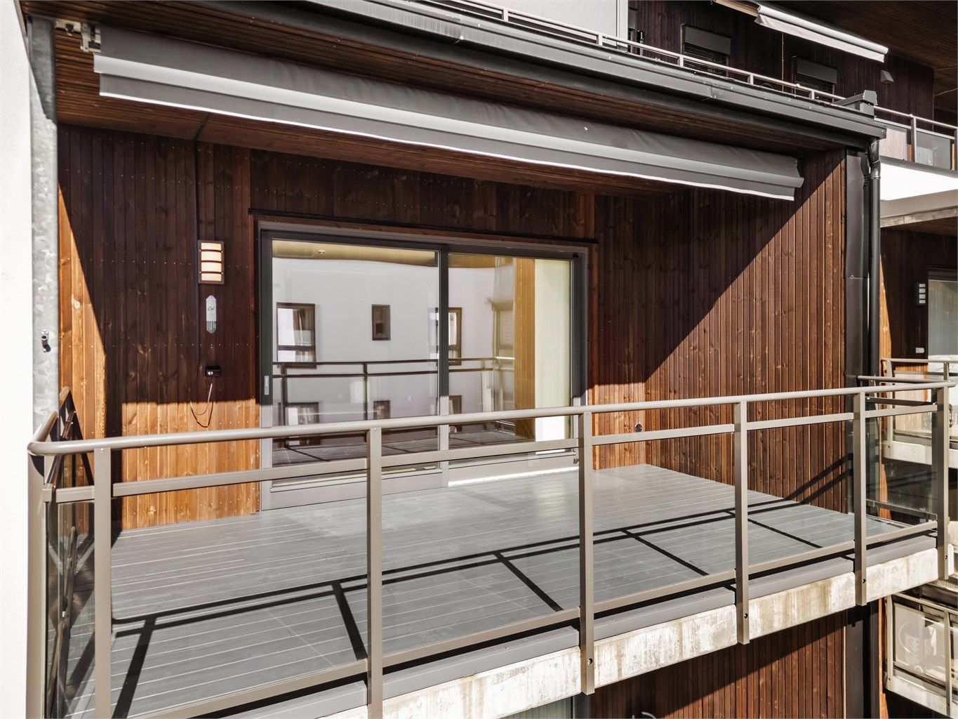 Overbygget balkong på 15 kvm med markise, utvendig belysning, strømuttak og terrassebord på gulv.