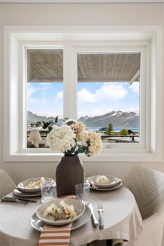 Spiseplassen ved kjøkkenvinduet rammer inn utsikten mot fjell og fjord.