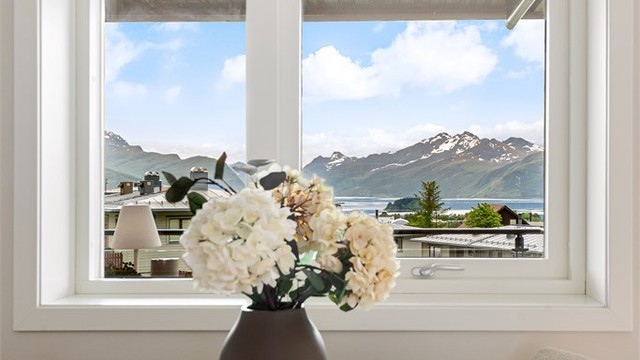 Spiseplassen ved kjøkkenvinduet rammer inn utsikten mot fjell og fjord.