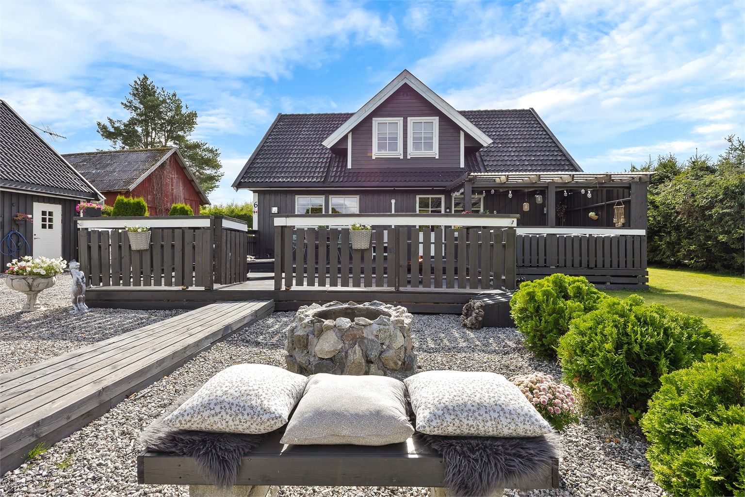 Uteområdet er pent opparbeidet med plen, grus og beplantning.