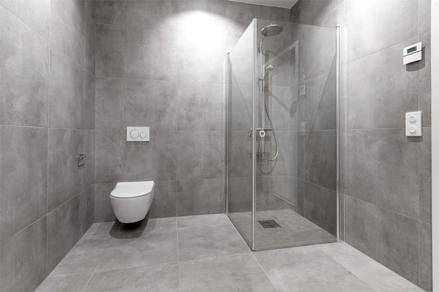 Bad i underetasjen med dusjhjørne med hånddusj og regndusj. Vegghengt toalett