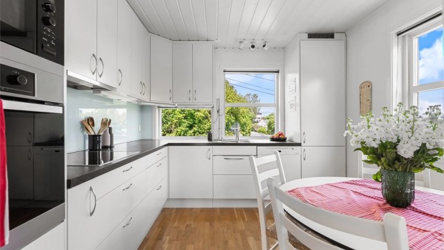 Kjøkkeninnredning fra 2011 med glatte fronter og benkeplate med laminert overflate.