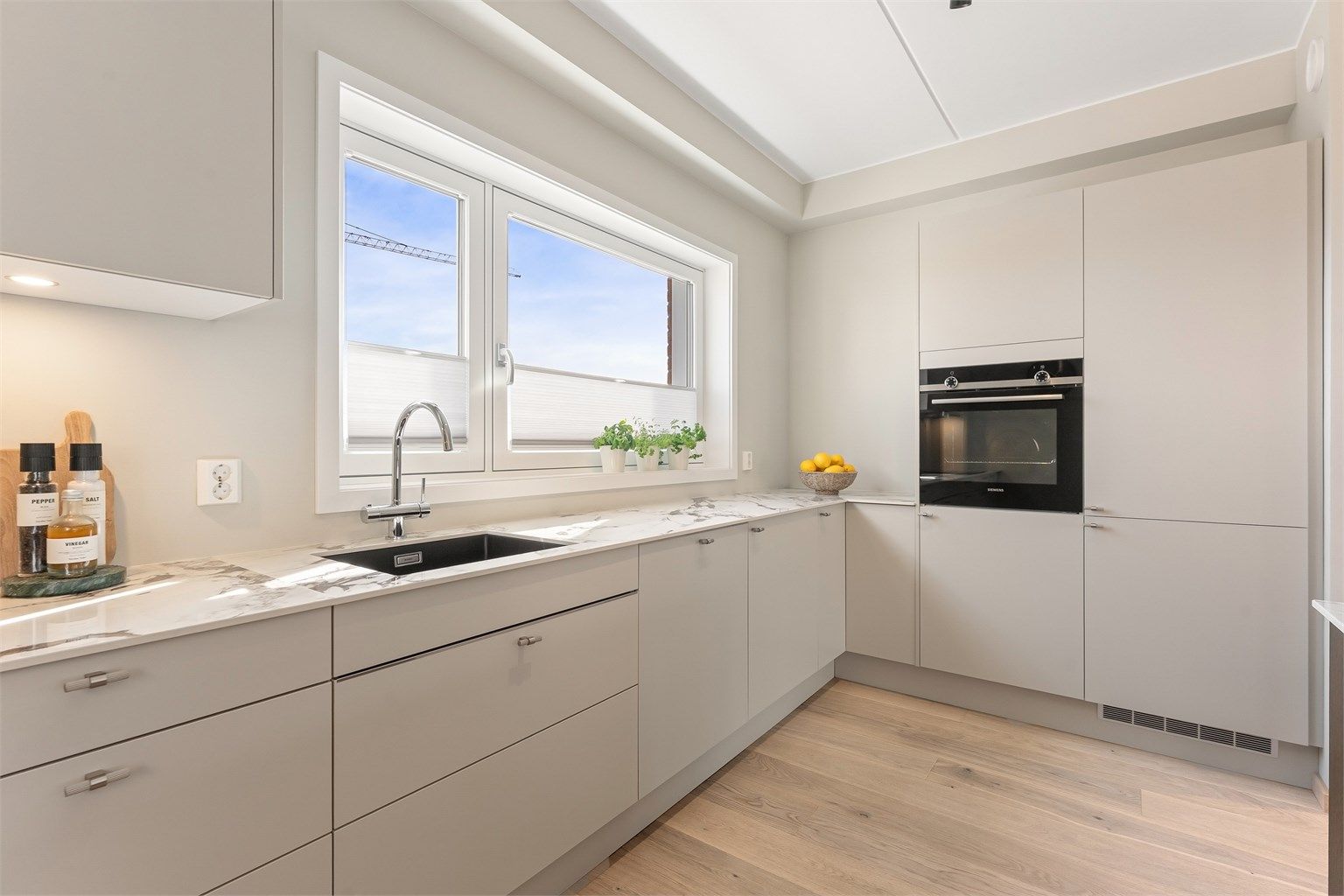 Kjøkkenet er utstyrt med integrert platetopp, stekeovn, oppvaskmaskin, kjøleskap med fryser og vinskap