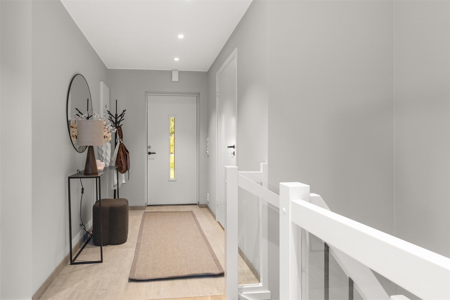 Entré med gulvfliser med varmekabler og downlights i himling. Ny ytterdør i 2025