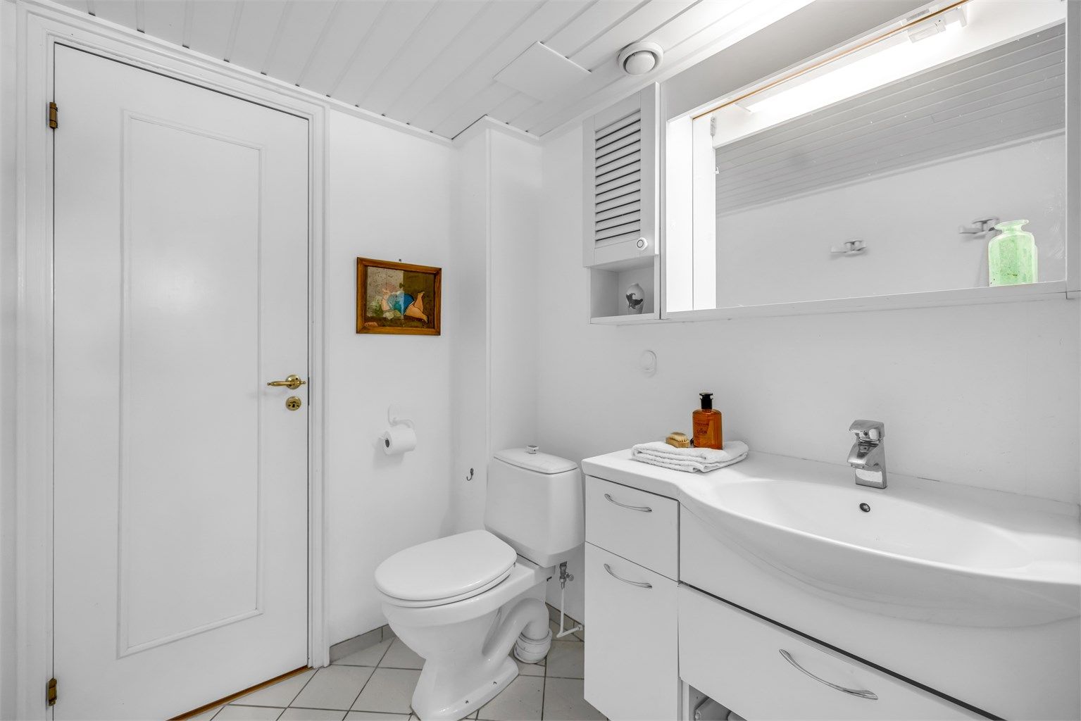 Badet er innredet med servantinnredning med heldekkende servant, speilskap med belysning og stikkontakt, gulvstående toalett samt frittstående badekar med dusjløsning.