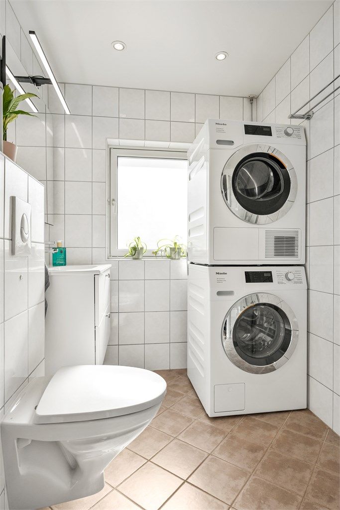Badet er utstyrt med vegghengt toalett, servantinnredning og opplegg for vaskesøyle.