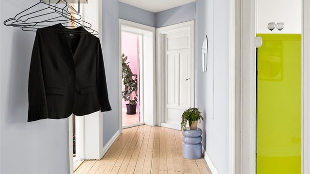 Leiligheten har adkomst via felles trappegang med callinganlegg, og har profilert to-fløyet entrédør av tre med glassfelt. Gangen har også plass til skap/kommode.