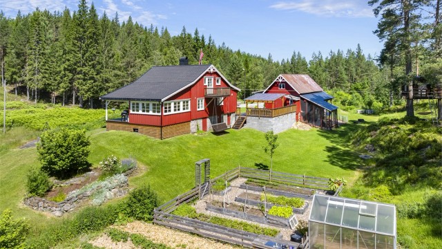 Oversikt over tunet med bolighus, låve og garasje.