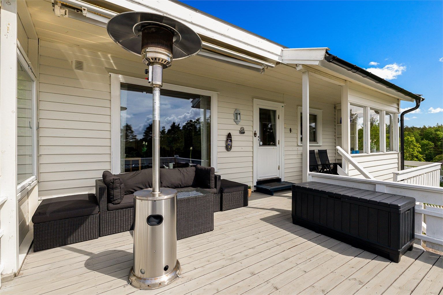 Terrassen ved inngangen til hytta er delvis overbygget og har terrassemarkise.
