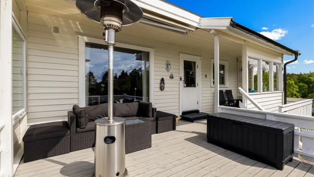 Terrassen ved inngangen til hytta er delvis overbygget og har terrassemarkise.