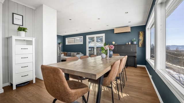 Gjennomgående parkettgulv binder sammen stue, spisestue og kjøkken på en helhetlig måte.