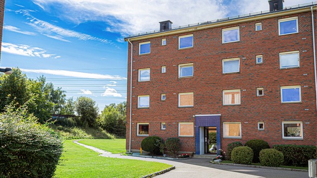 Rundt blokken er det velholdte omgivelser med frodige grøntarealer og en rolig atmosfære.