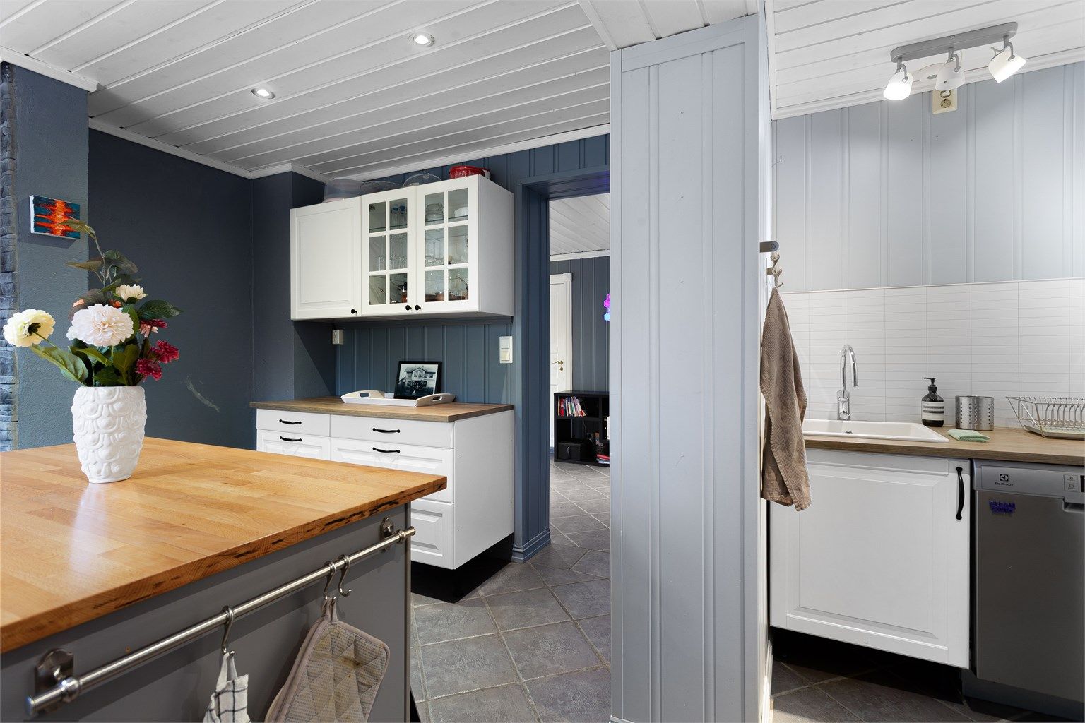 Praktisk, skjermet krok til oppvasken med laminert benkeplate nedfelt kjøkkenkum og oppvaskmaskin under benkeplaten