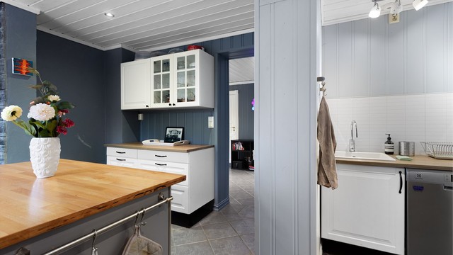 Praktisk, skjermet krok til oppvasken med laminert benkeplate nedfelt kjøkkenkum og oppvaskmaskin under benkeplaten