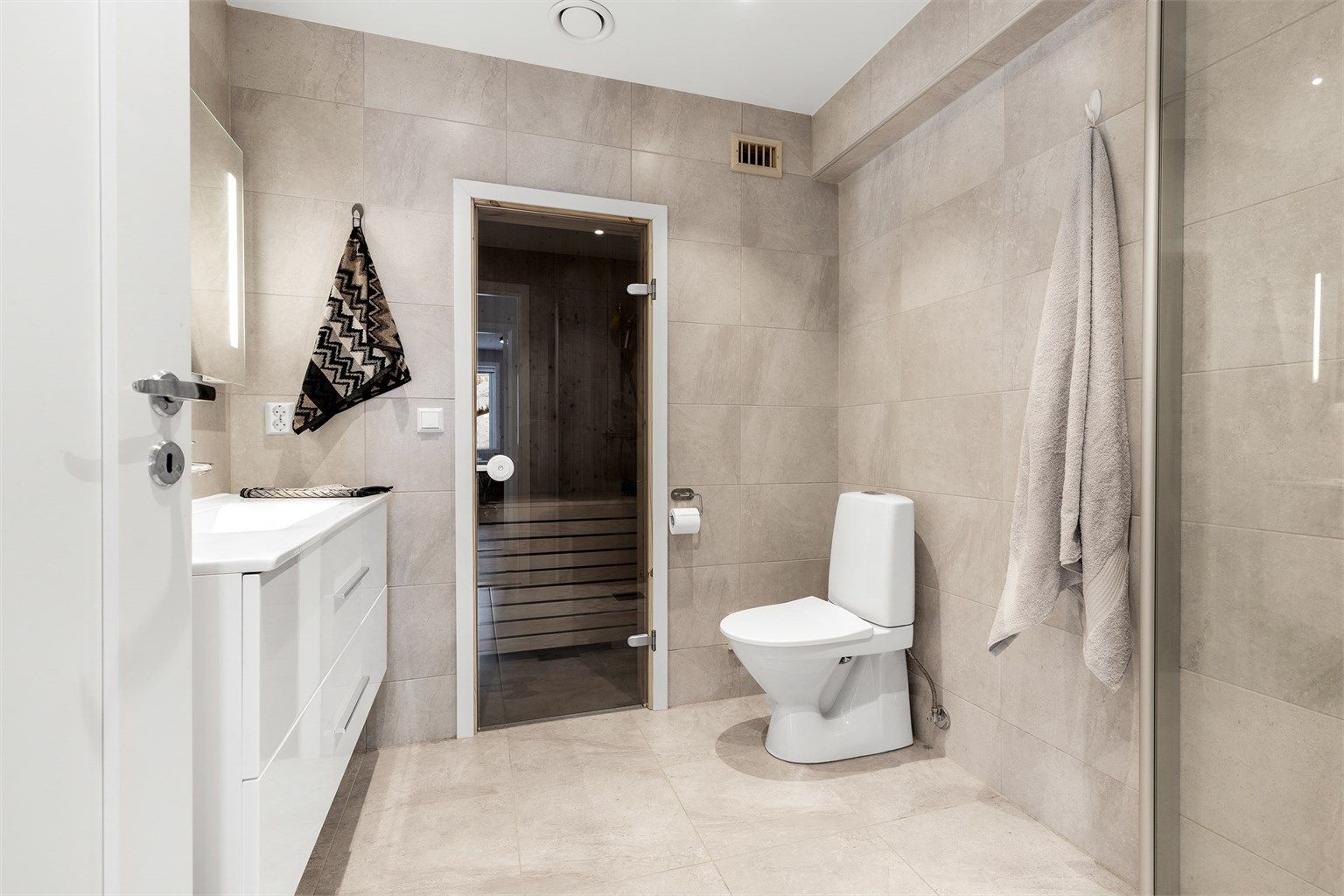 Badet har dusjhjørne med foldedører av glass