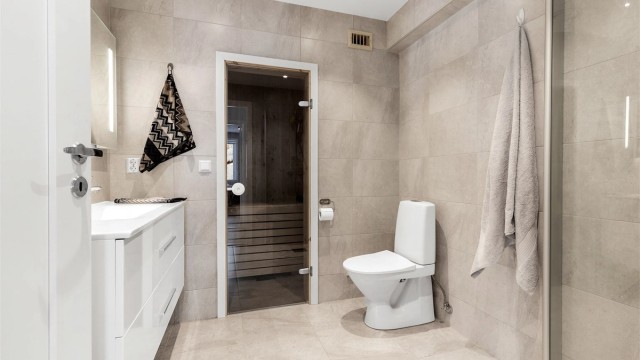 Badet har dusjhjørne med foldedører av glass