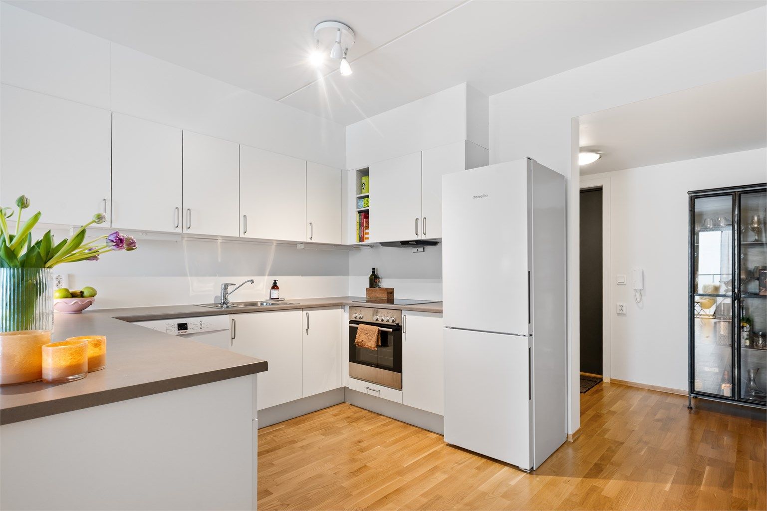 Kjøkkeninnredning med glatte fronter og laminert benkeplate, overskapsbelysning og stikkontakter