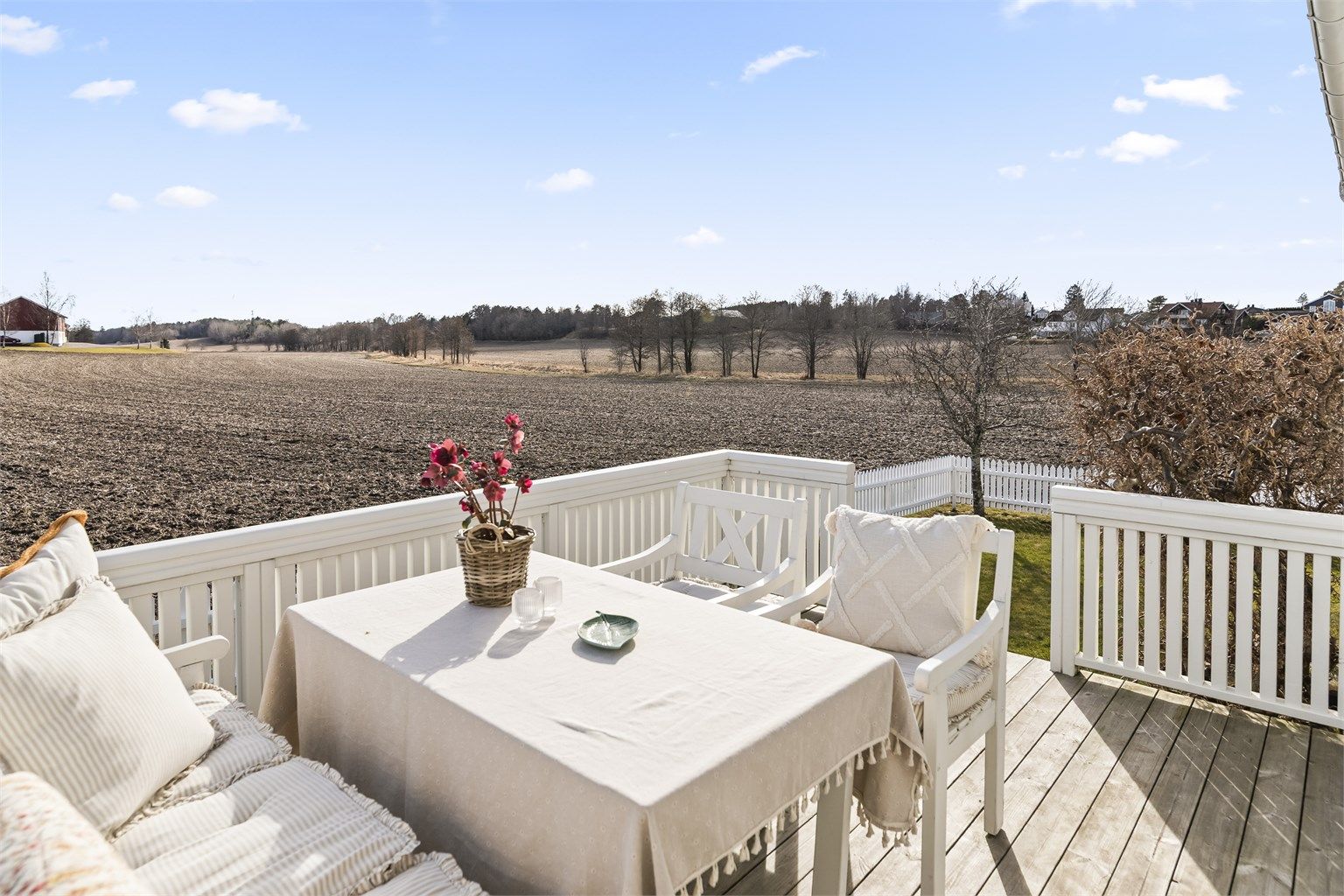 Terrassen har plass til en sittegruppe og har utsikt over hagen og jordene.