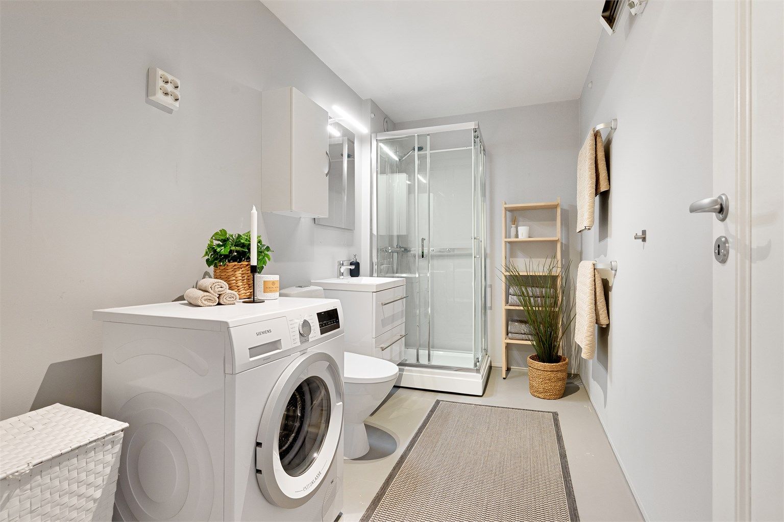 Baderommet har malte flater og er utstyrt med dusjkabinett og opplegg for vaskemaskin. Vaskemaskin medølger.