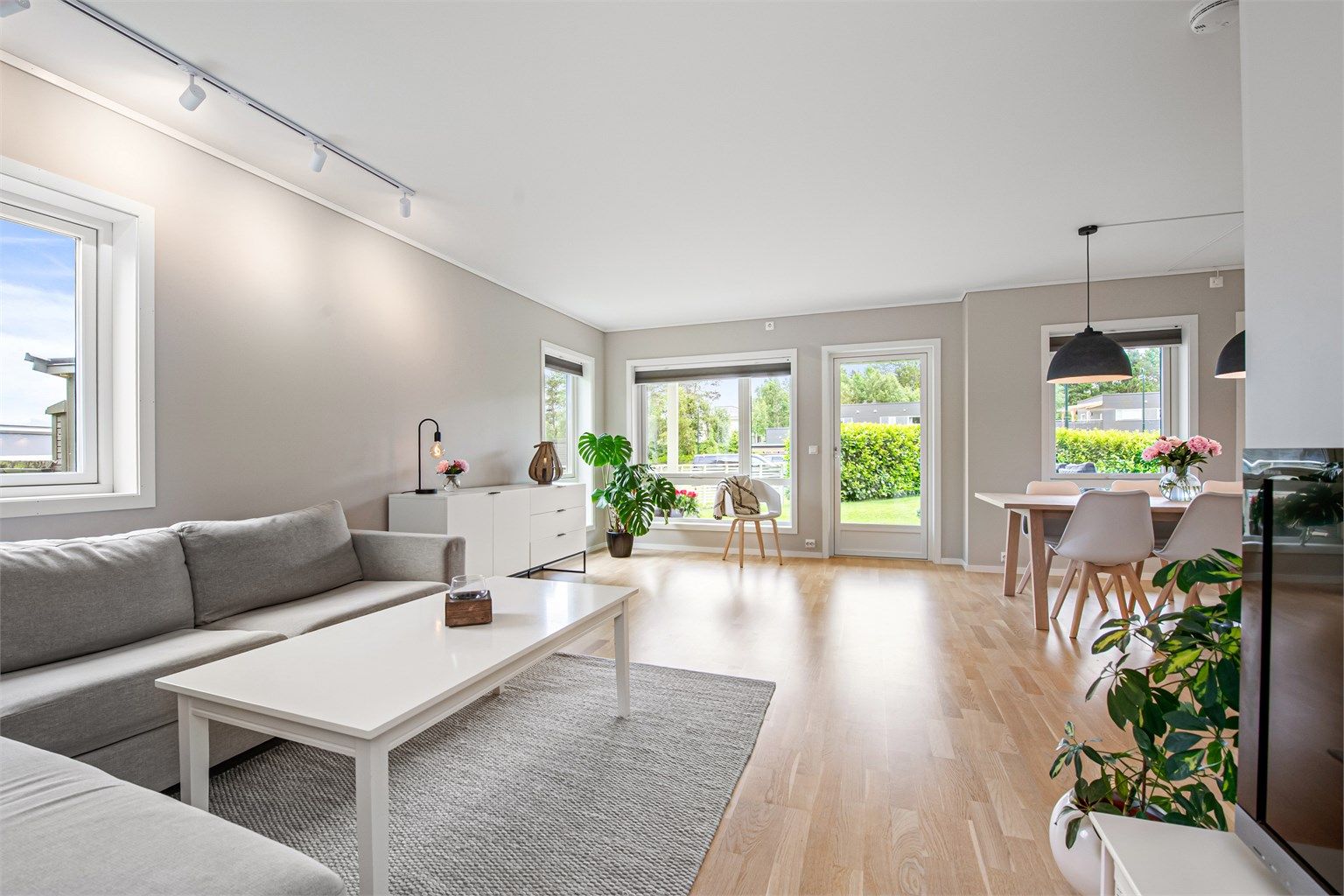 Stue med lyse overflater og god plass til både sofagruppe og spisestue