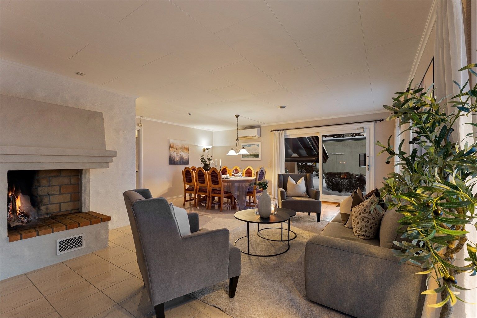 En sentralt plassert peis for vedfyring skaper en lun atmosfære.