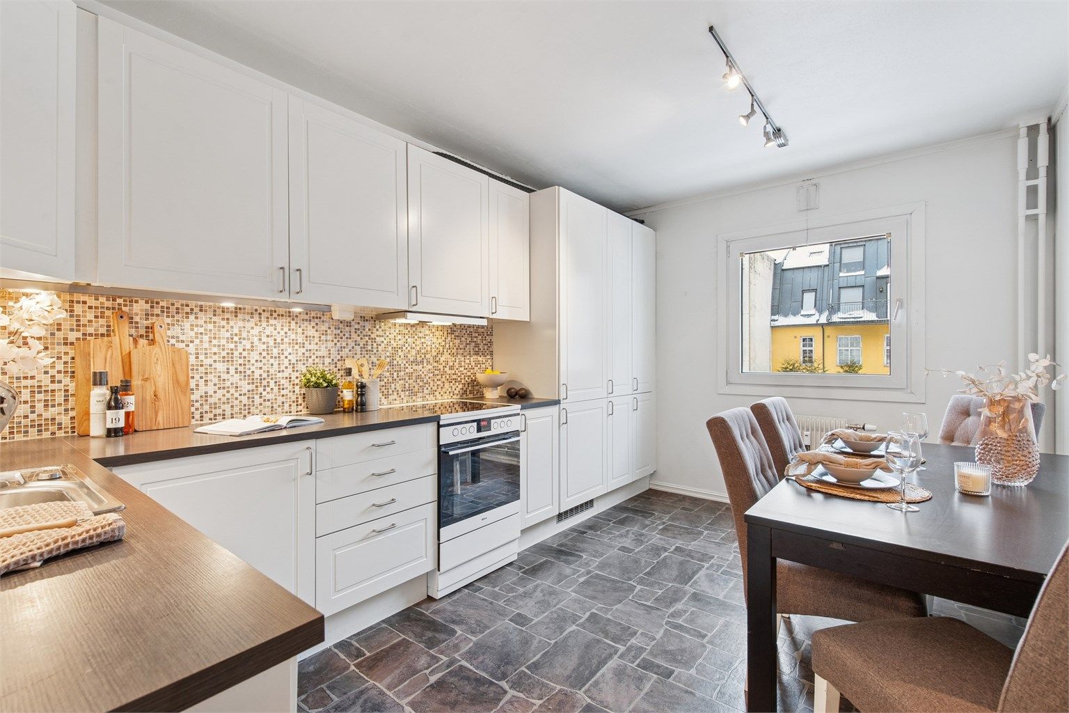 Kjøkkenet har en praktisk utforming med HTH-innredning, integrerte hvitevarer som oppvaskmaskin og kjøleskap, samt frittstående komfyr.