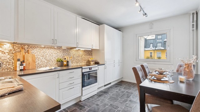 Kjøkkenet har en praktisk utforming med HTH-innredning, integrerte hvitevarer som oppvaskmaskin og kjøleskap, samt frittstående komfyr.