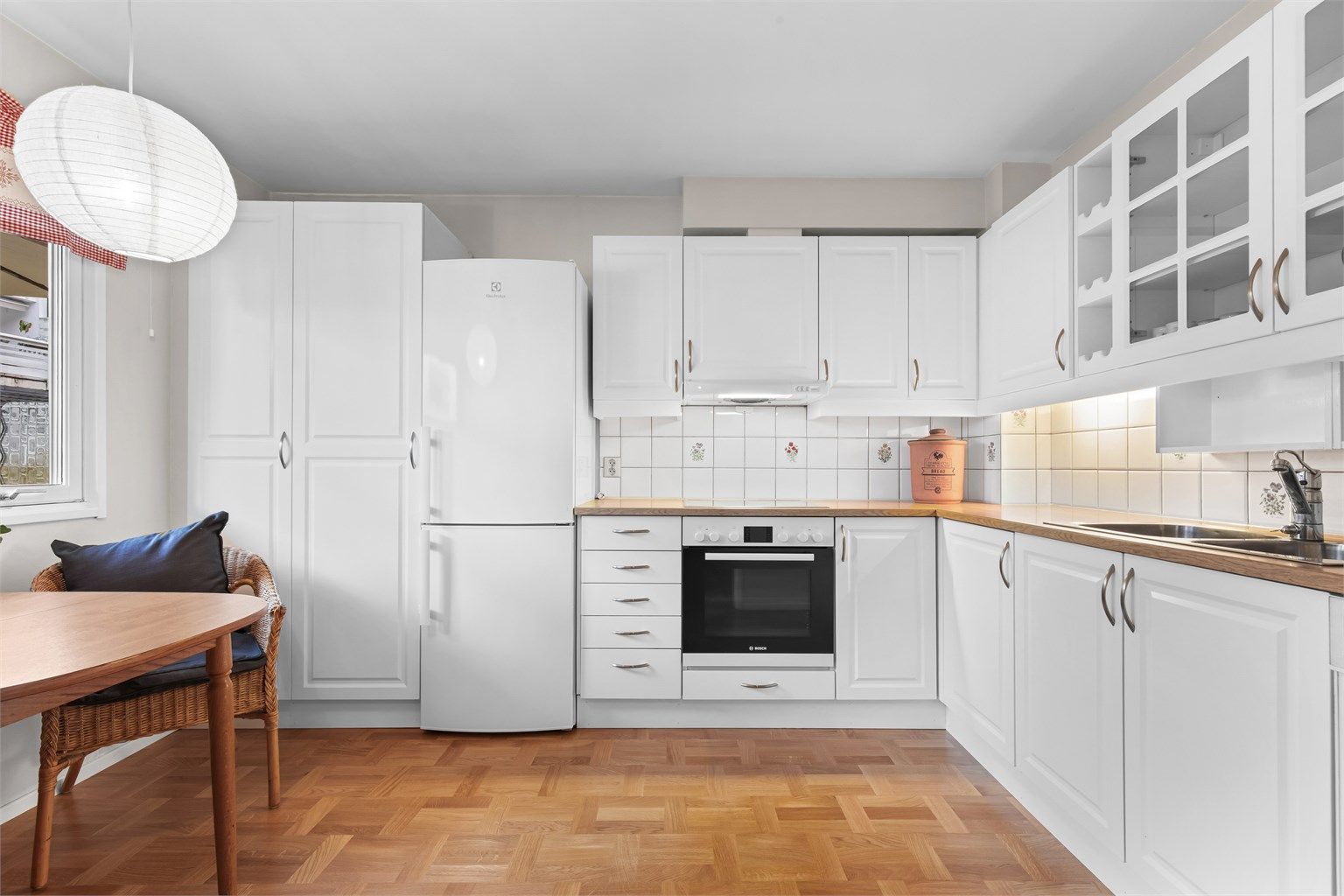 Kjøkkenet har en praktisk utforming med profilerte fronter og integrerte hvitevarer.