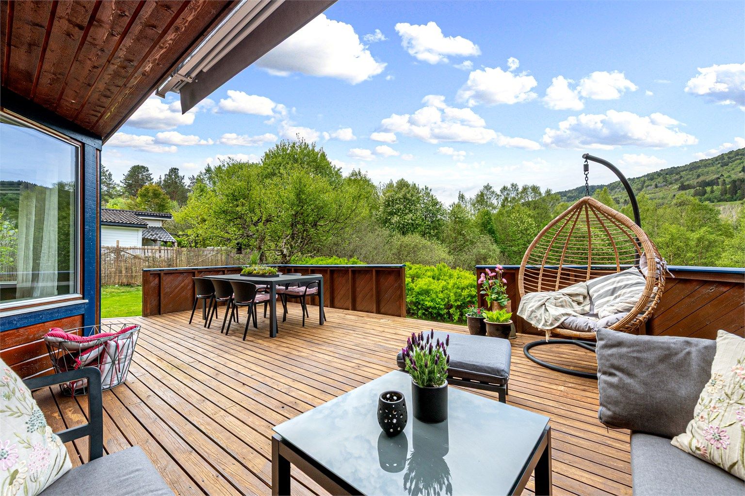 Det er stor terrasse rundt boligen og gode solforhold - her fra terrassen mot vest med utg. fra stue og med trapp/adkomst til hage