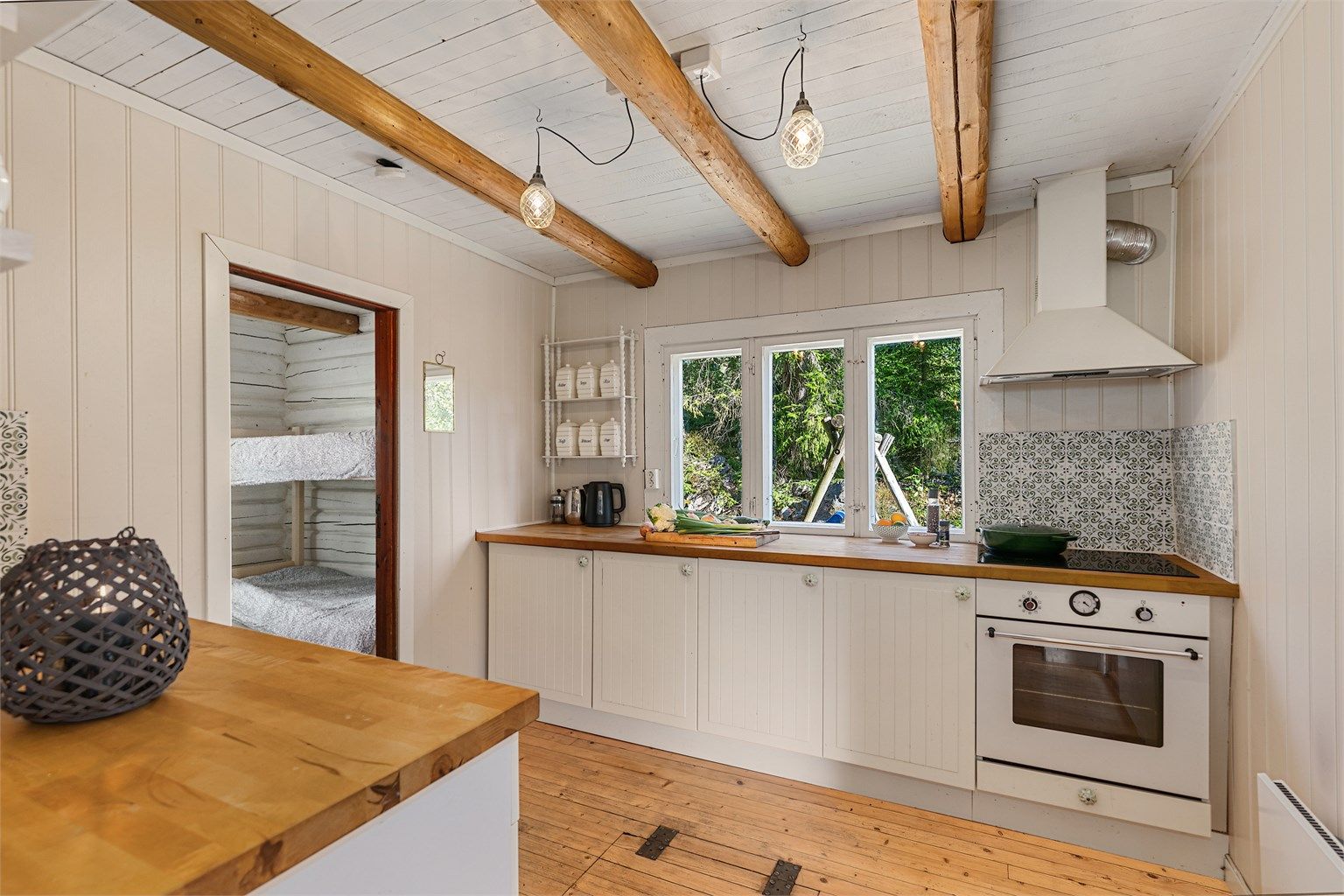 Lyst kjøkken med profilerte fronter, god oppbevaringsplass og vindu som slipper inn rikelig med dagslys