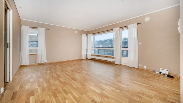 Romslig stue med store vindusflater og ny parkett lagt i 2025