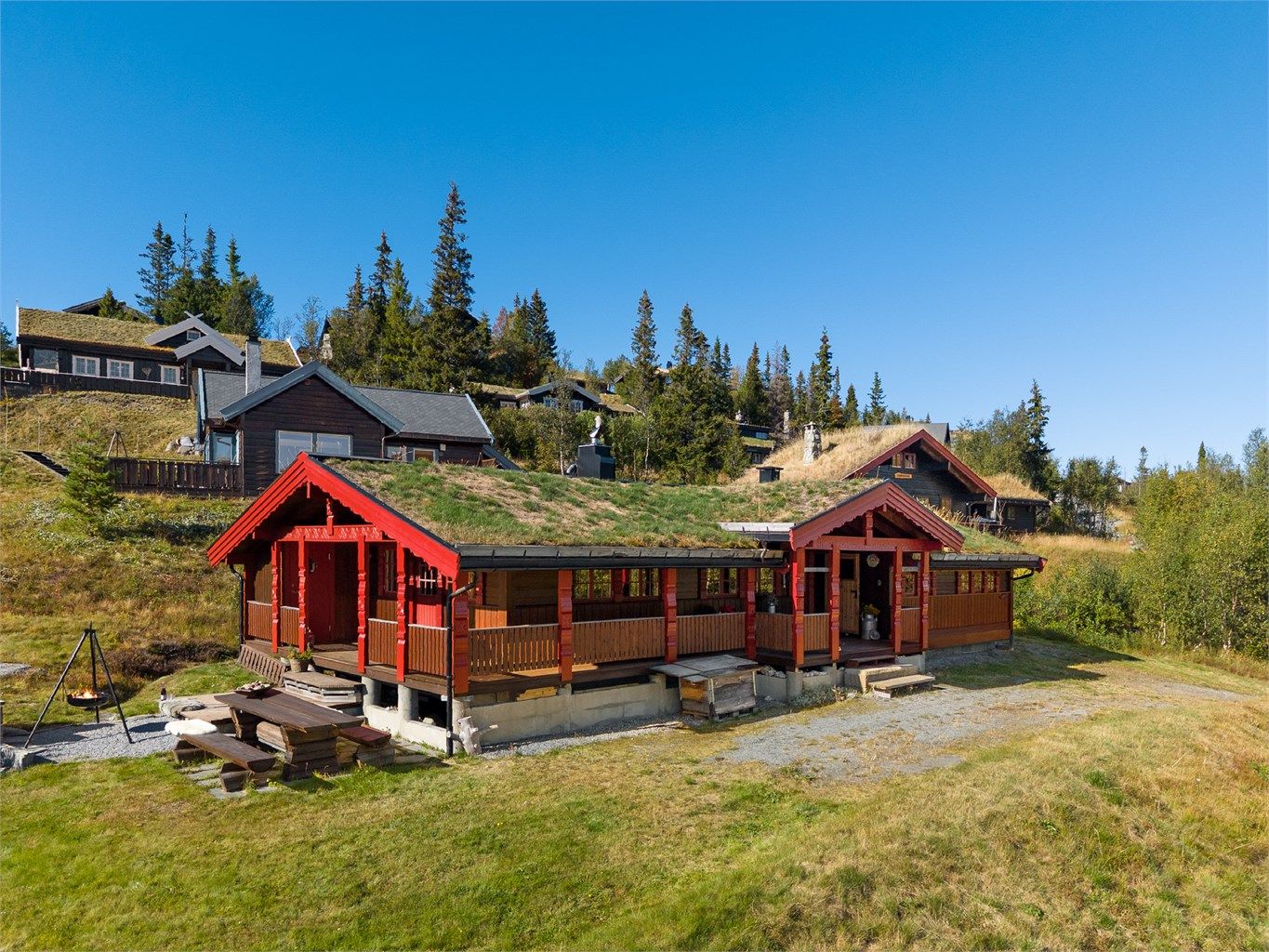 Den overbygde terrassen og fasadedetaljene gir hytta et helhetlig fjellpreg.