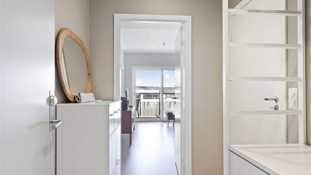 Lys og innbydende entré med plass til oppheng av tøy og oppbevaring av sko