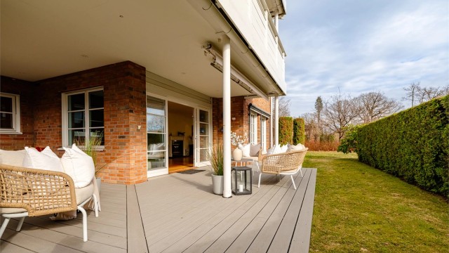 Stor og usjenert terrasse med adkomst fra stuen.