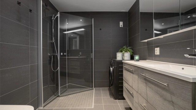 Badet har elektrisk gulvvarme og et dusjhjørne med innfellbare glassdører.