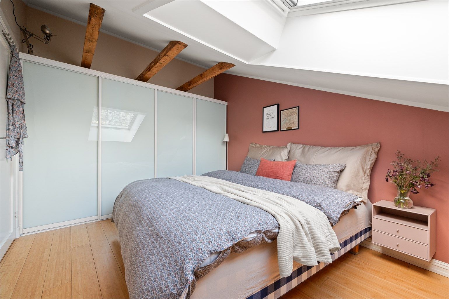 Soverommet har parkett på gulvet og synlige bjelker i taket.
