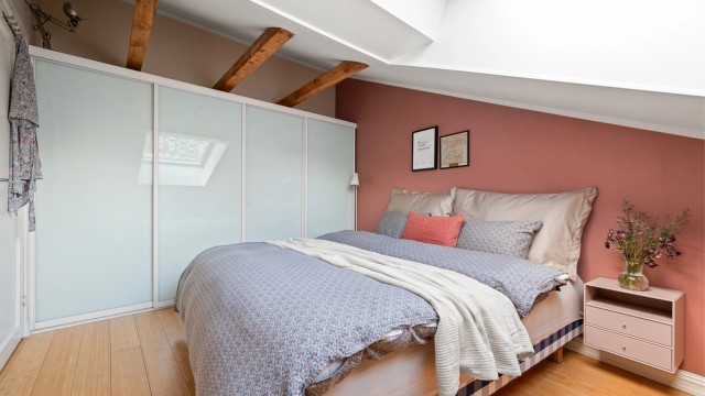 Soverommet har parkett på gulvet og synlige bjelker i taket.