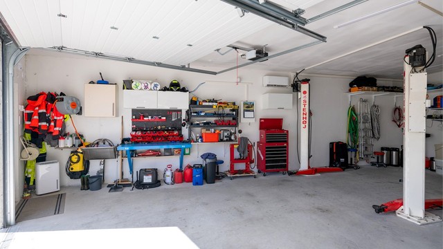 Garasjen er innredet med gode lagringsmuligheter og romslig plass for arbeidsbenk.