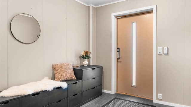 Entréen ønsker velkommen med flislagt gulv med elektrisk gulvvarme. Ytterdøren har elektronisk kodelås.