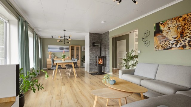 Stuen har plass til både sofagruppe og spisebord, og varmes effektivt opp av en varmepumpe.