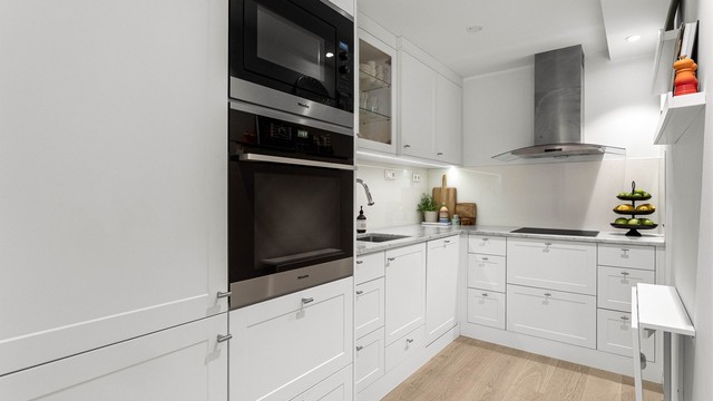 Kjøkkenet er innredet med integrerte Miele-hvitevarer og en tidløs materialpalett.