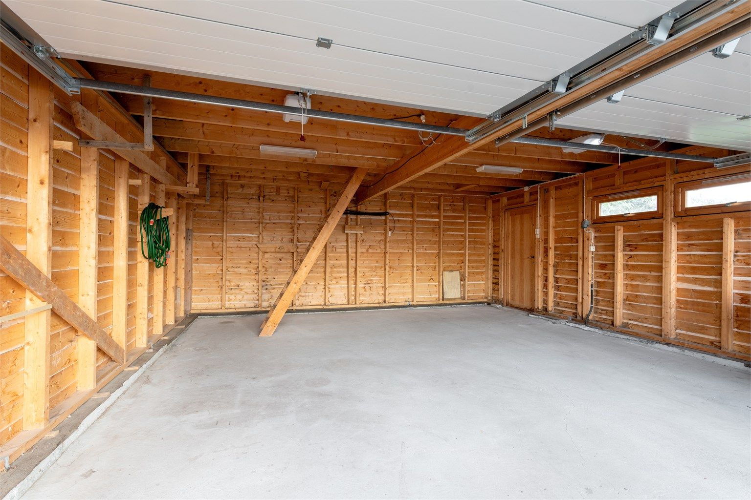 Innvendig i garasjen med trapp til loft med lagringmulighet