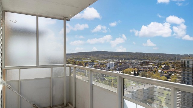 Balkongen har rekkverk i metall og glass, og et solid betongdekke.