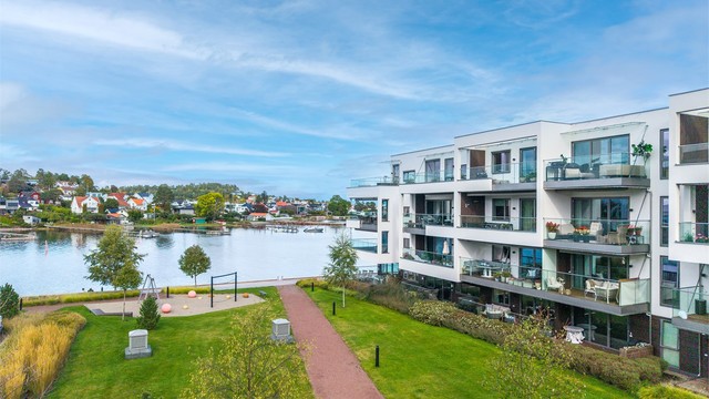 Pent opparbeidede fellesområder med plen, gangstier og beplantning.