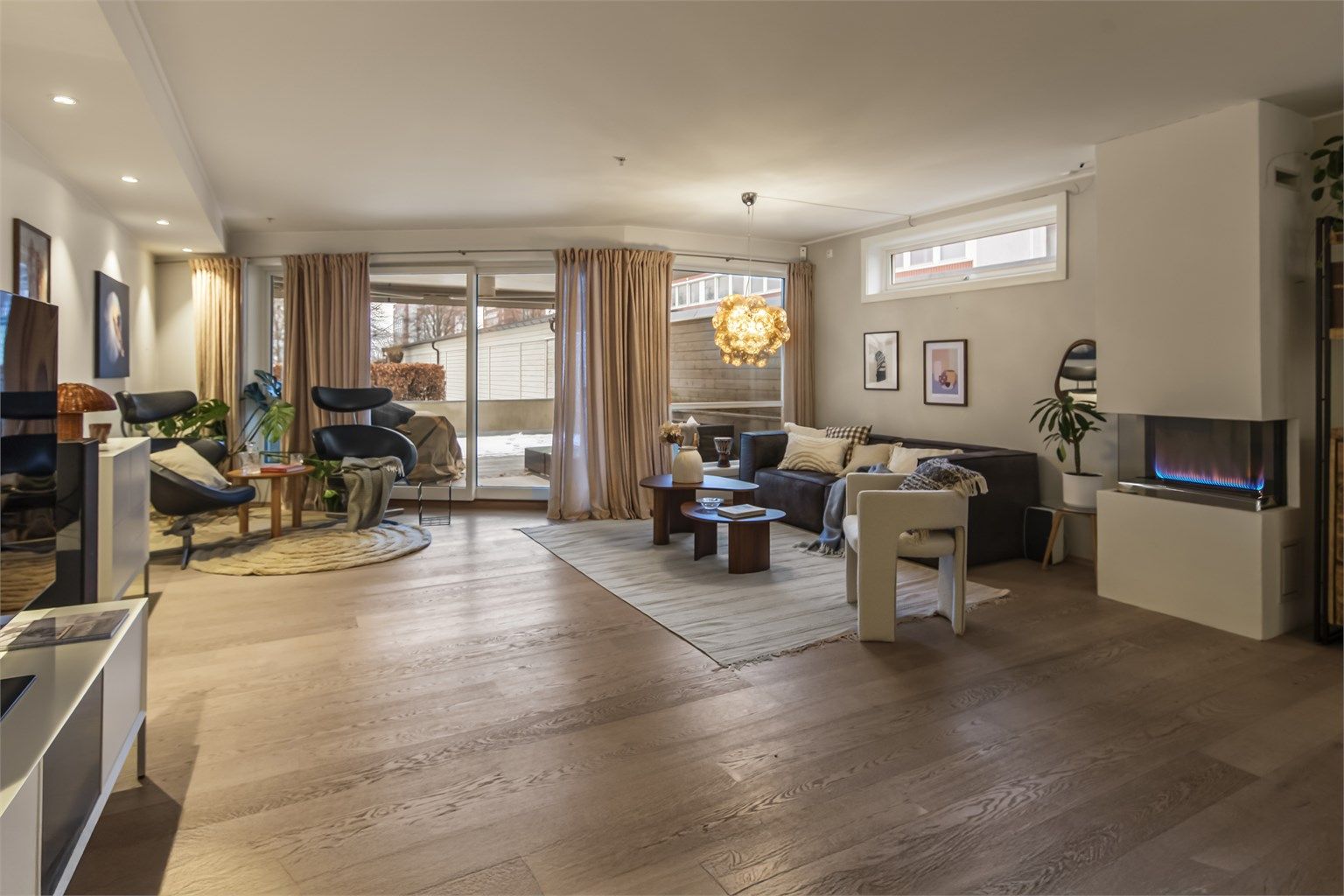 Stuen er lys og innbydende med naturlig lys fra store vindusflater og utgang til stor terrasse