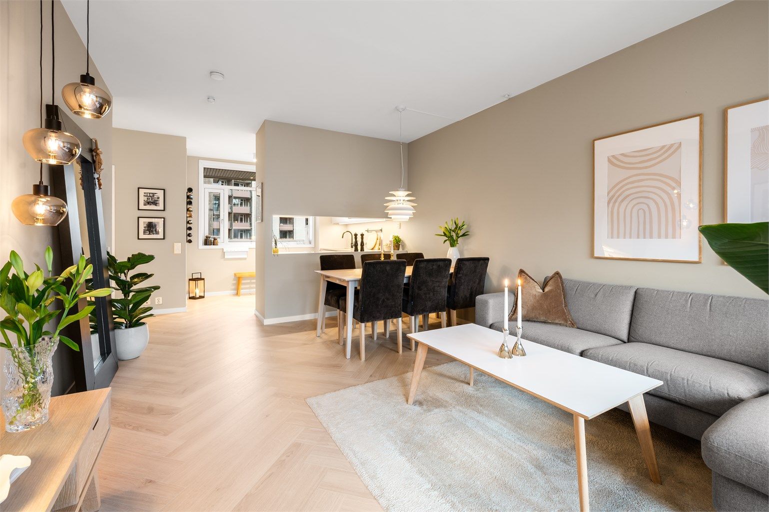 Stue og kjøkken i en delvis åpen løsning skaper en sosial og luftig atmosfære.