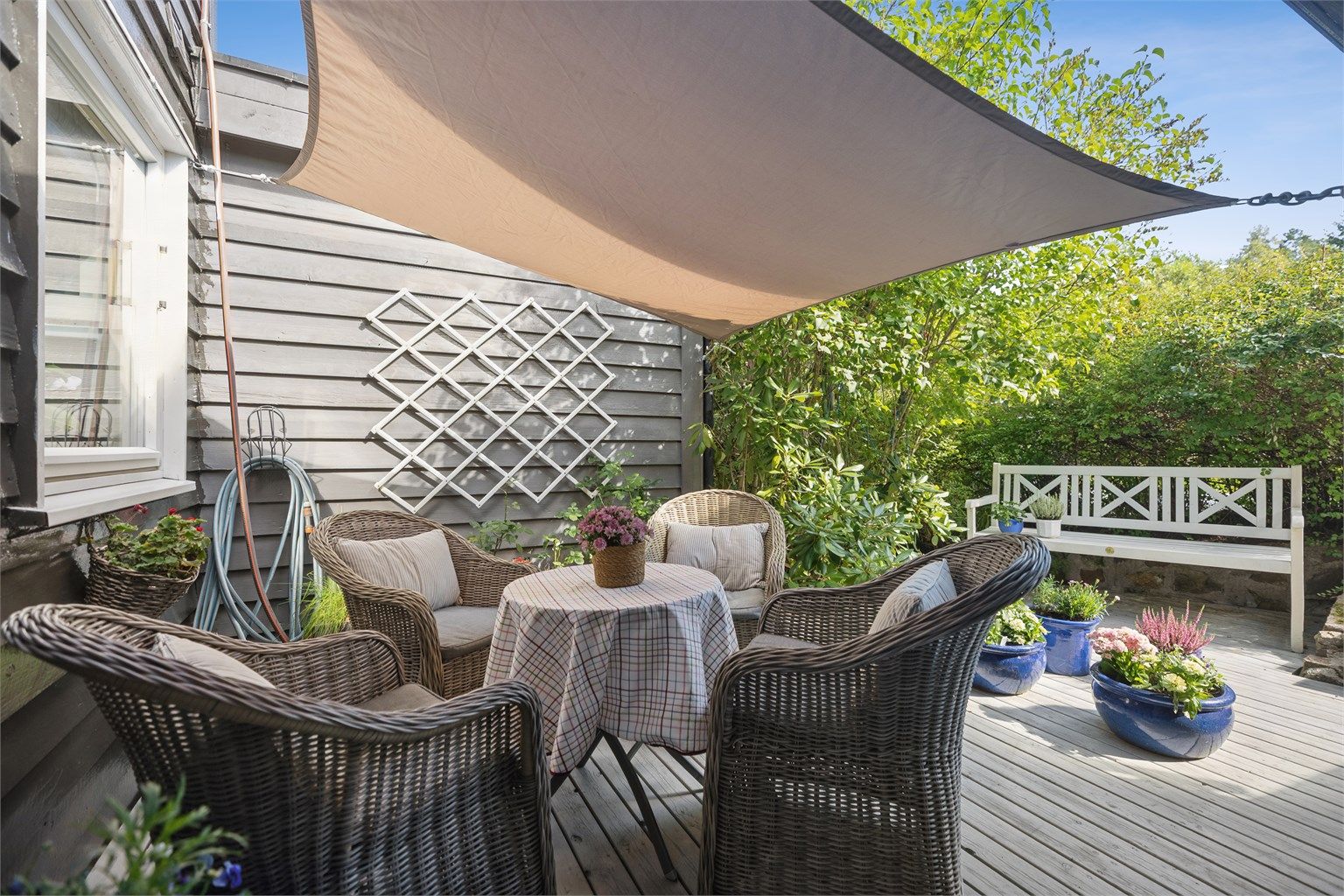 Her sitter du omringet av flotte planter og naturlige omgivelser – en skjermet plass som gir både ro og privatliv.