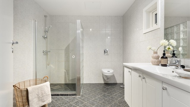 Badet er på 7,2 kvm. Vegghengt toalett og romslig dusjsone.