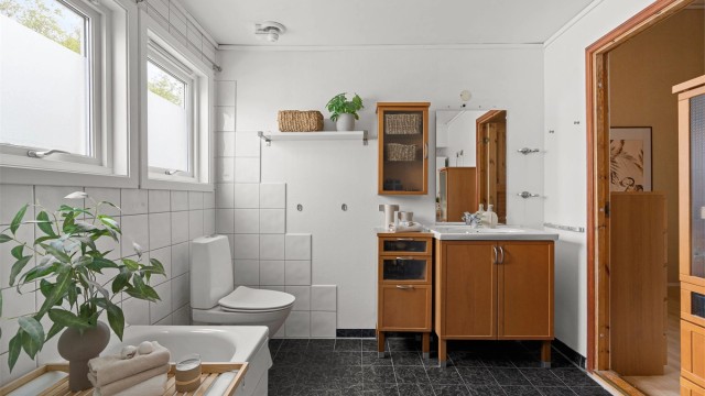 Innredningen består av gulvstående servantinnredning, badekar med vegghengt badekararmatur og gulvstående toalett. Mekanisk avtrekksvifte i himling.