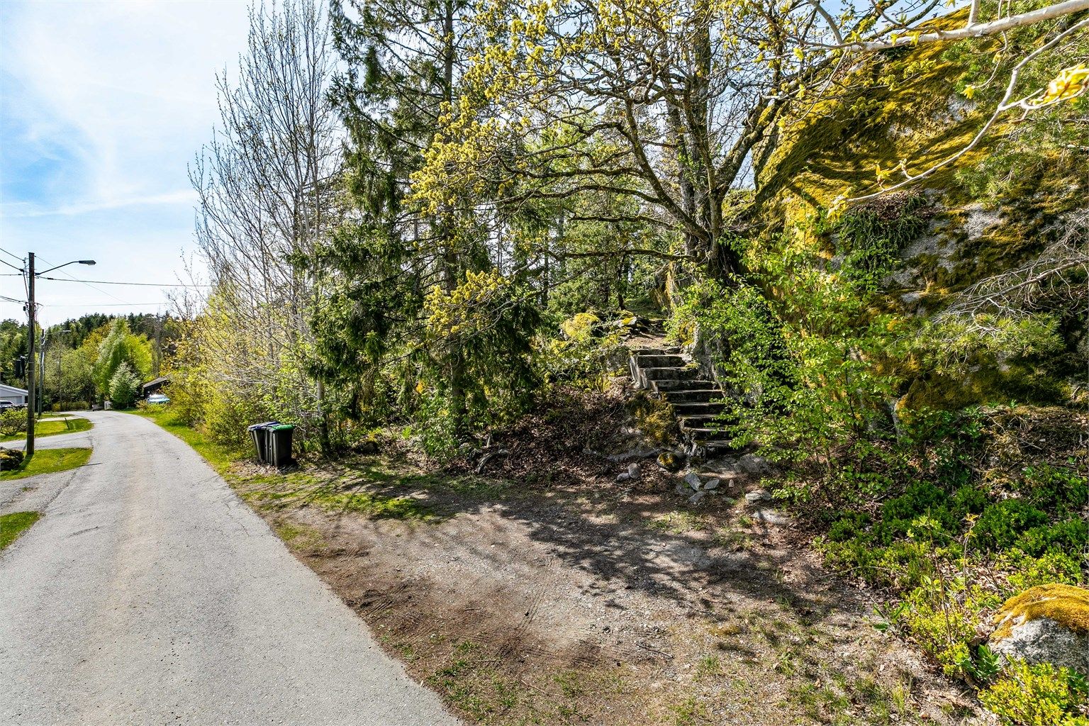 Det er adkomst til boligen også via oppmurede trapper fra biloppstillingsplass inntil den kommunale veien Hakkeråsen. 